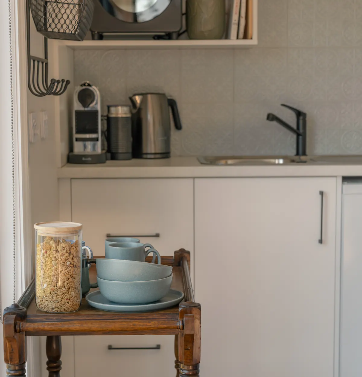 The kitchen bench, with the coffee machine, kettle and crockery