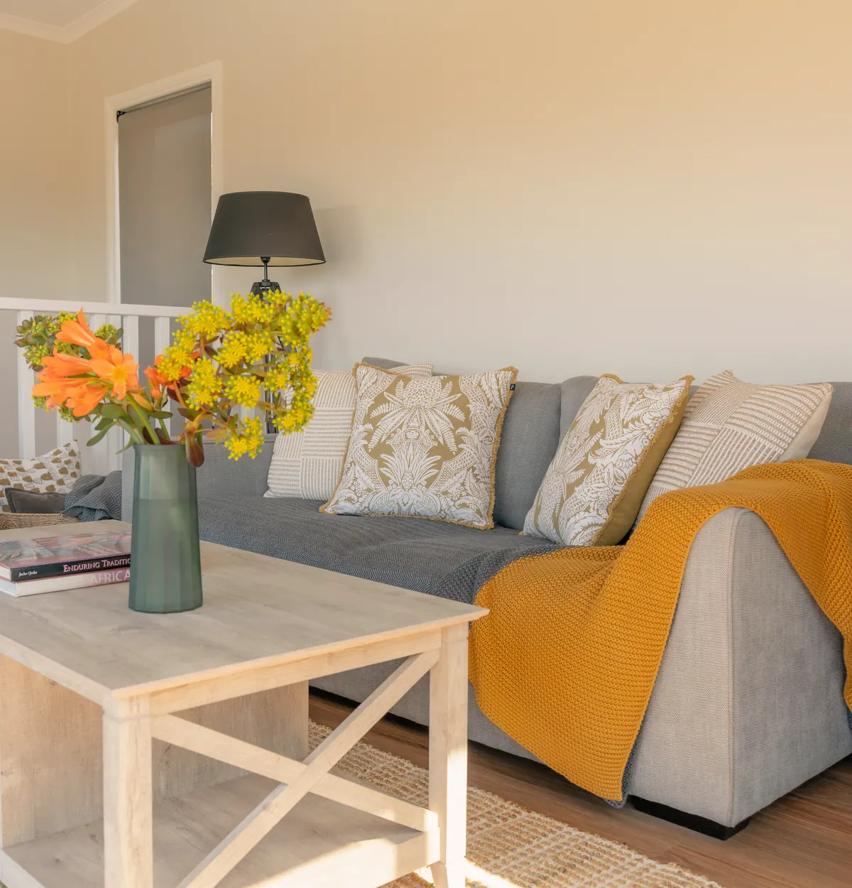 The upstairs lounge, with a sofa, a throw and fresh flowers on the table