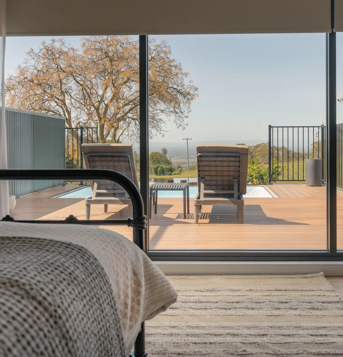 The bedroom, with the sliding doors open to the deck and the view beyond