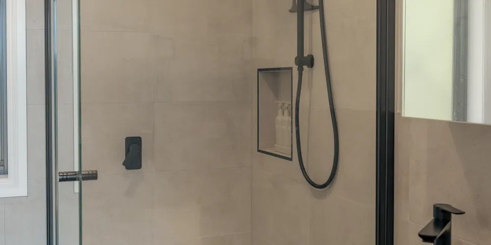 The bathroom's walk-in shower behind glass