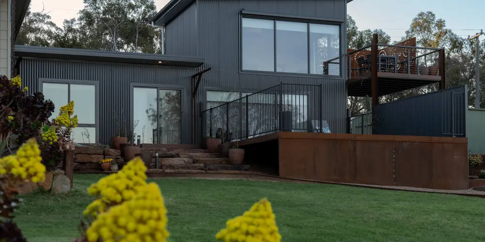 The accommodation seen from the lawn, with the garden beds in front