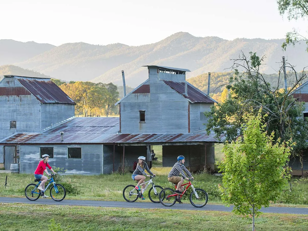 Cyclists on the rail trail passing the old timber mill