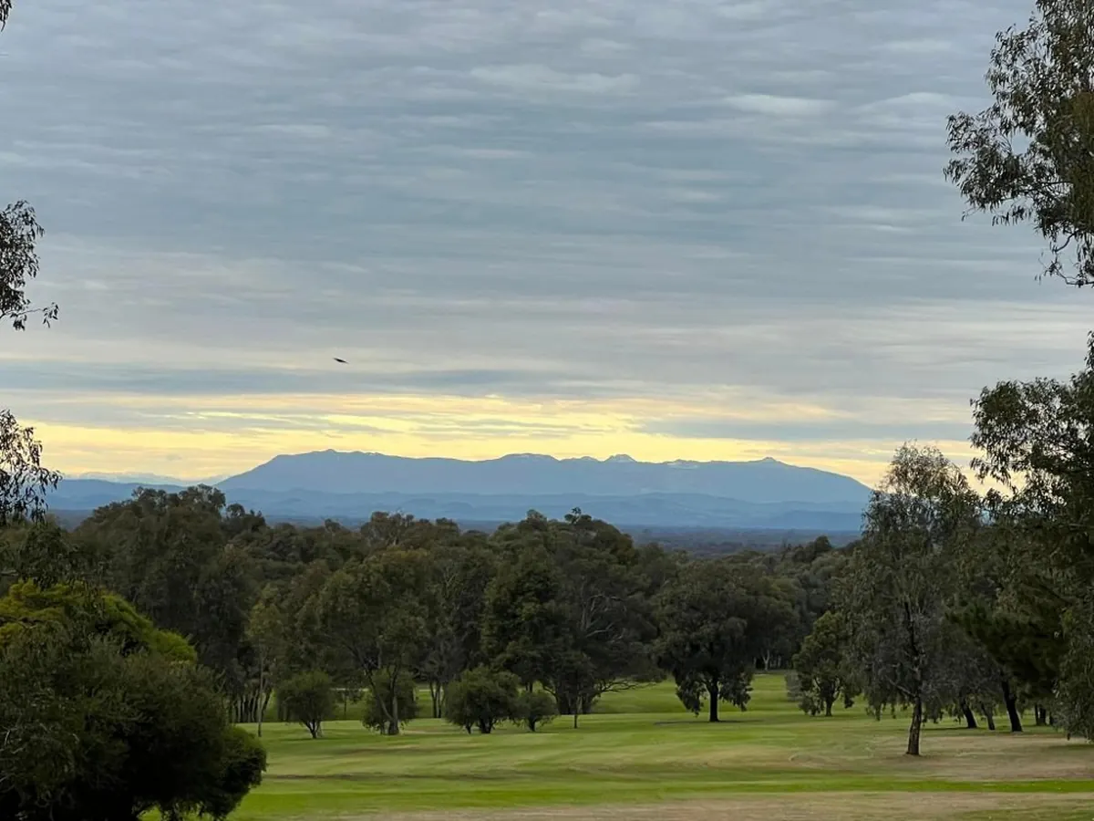 A fairway at the Jubilee Golf Club at dusk, edged by bushland