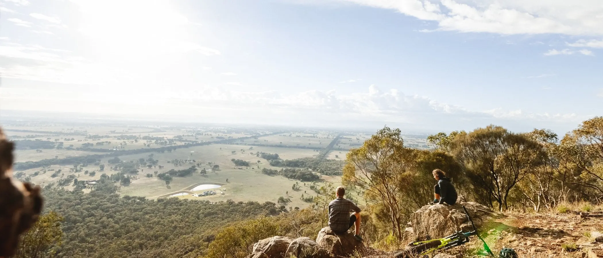 Walkers on a granite outcrop in the Warby Range National Park, looking over the plains
