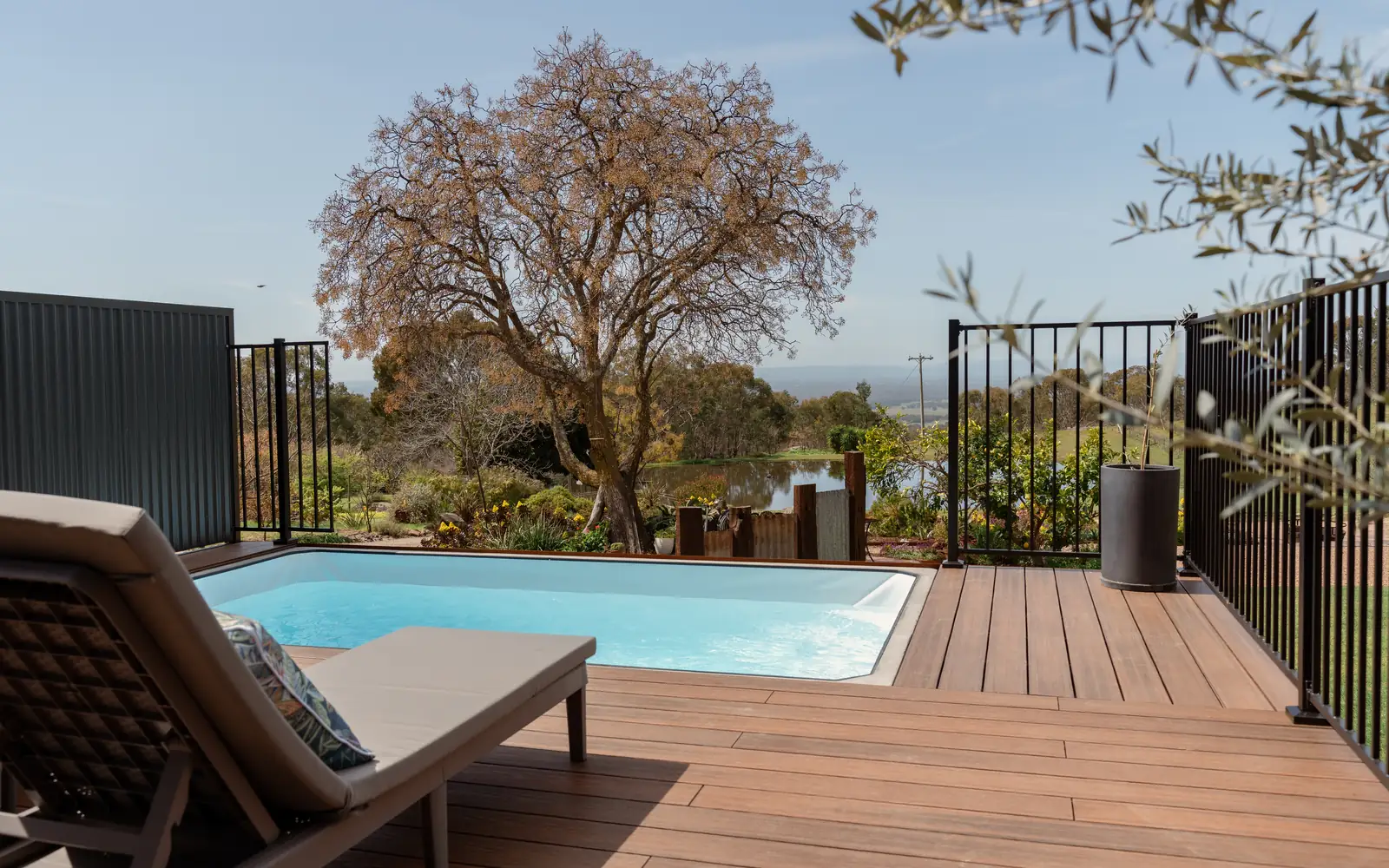 The plunge pool and its lounger under the tree, with the range behind